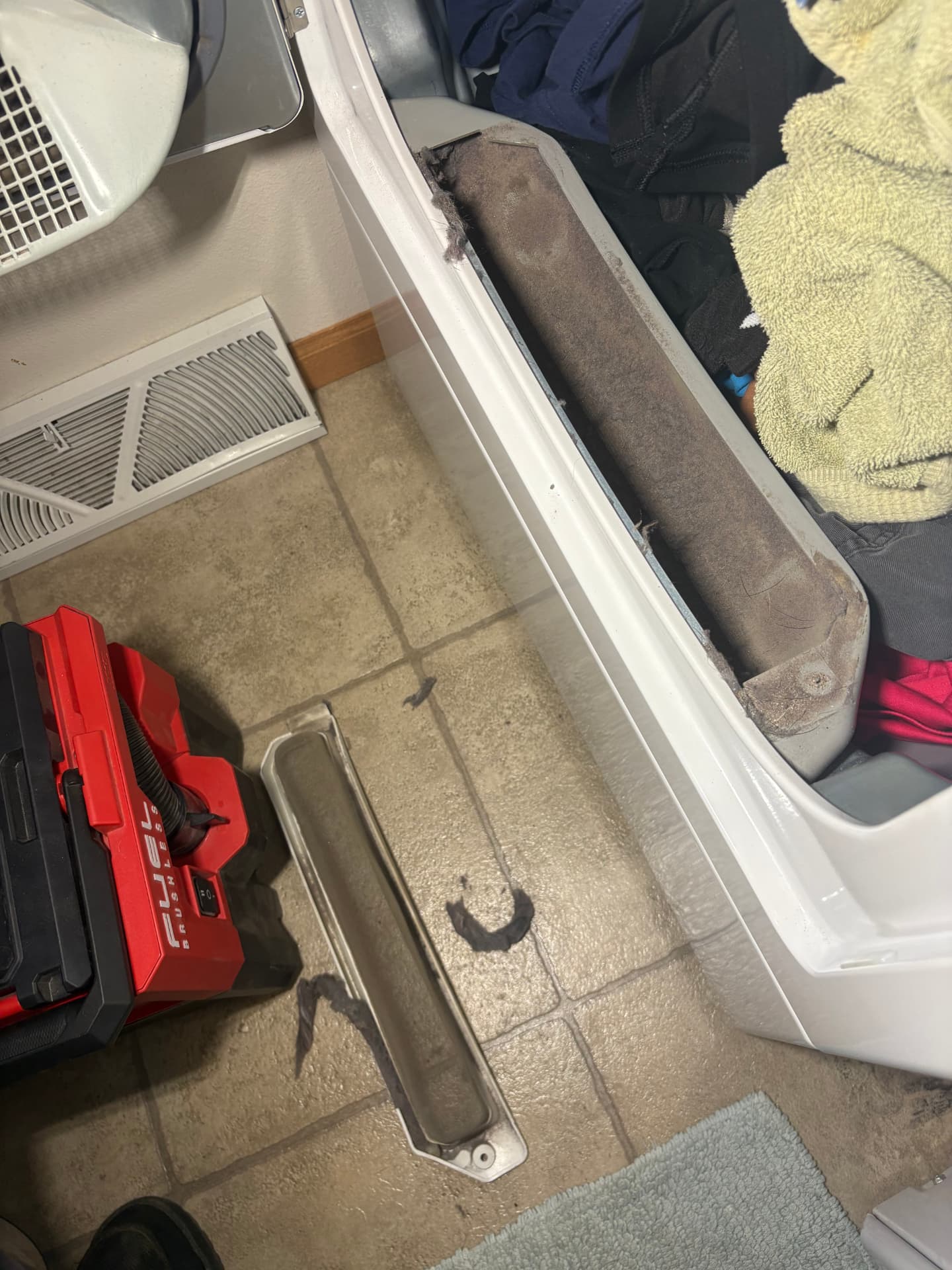 Dryer vent line and cleaning tools at the dryer inside a home.