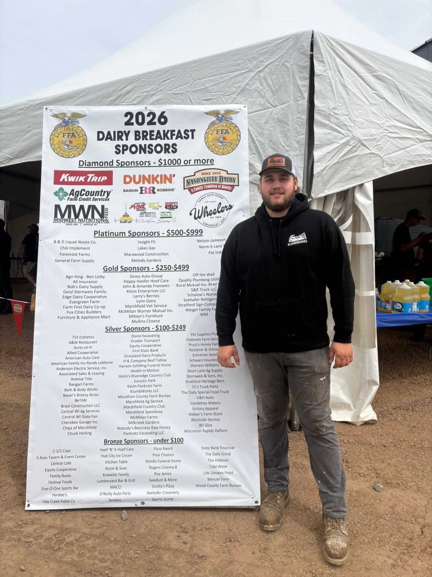Jon of KlumbWorks LLC standing beside the 2026 Marshfield FFA Alumni Dairy Breakfast sponsor board.